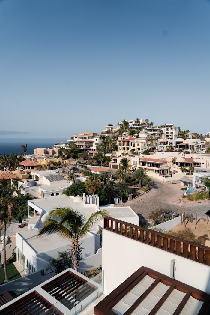 Panoramic view of luxury villas in Cabo San Lucas, Mexico under a clear blue sky.